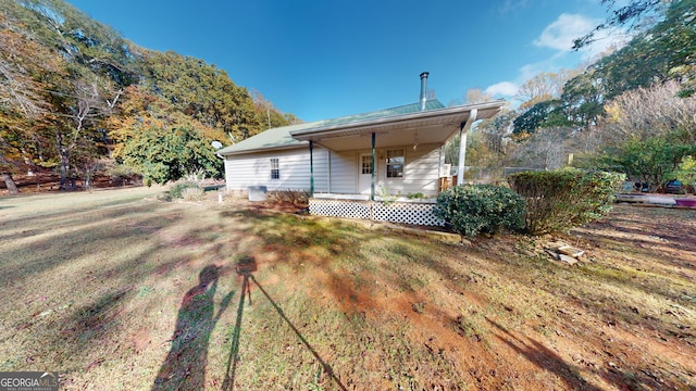 rear view of house with a lawn and covered porch