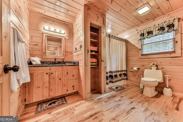 bathroom with vanity, wooden walls, wood ceiling, hardwood / wood-style flooring, and toilet