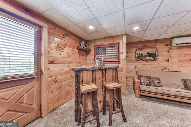 sitting room with bar area, wood walls, and carpet flooring