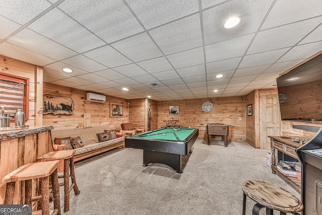 rec room featuring a paneled ceiling, carpet flooring, wood walls, pool table, and a wall unit AC