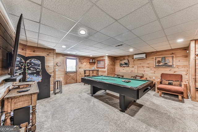 recreation room featuring carpet flooring, a wall unit AC, and a drop ceiling