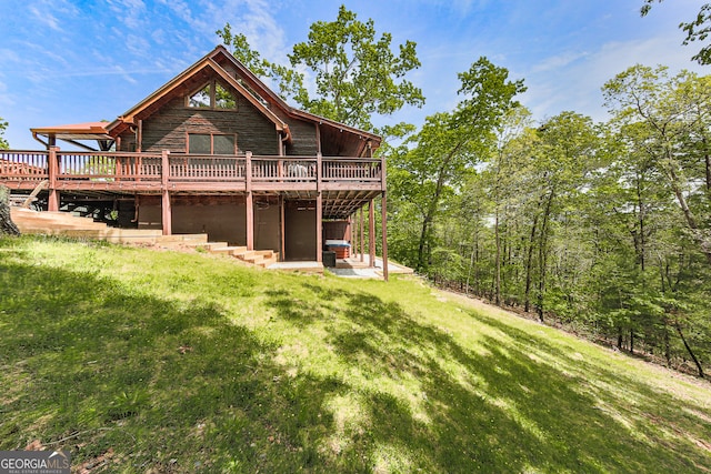 rear view of property featuring a yard and a deck