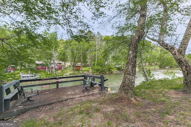 view of yard with a deck with water view