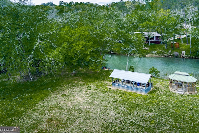 view of dock with a yard and a water view