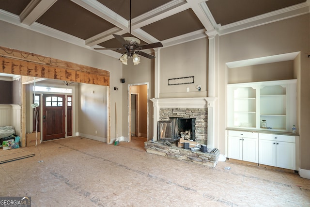 unfurnished living room featuring ceiling fan, a stone fireplace, beam ceiling, and coffered ceiling