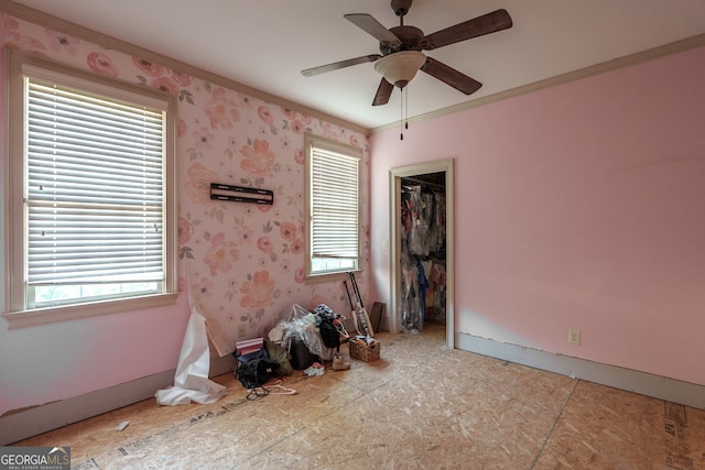 spare room featuring ceiling fan, a healthy amount of sunlight, and ornamental molding