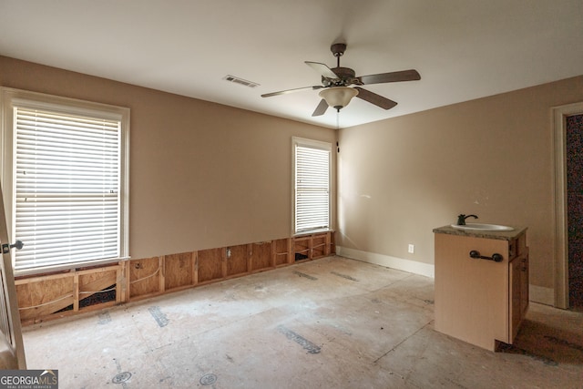 empty room with ceiling fan, a healthy amount of sunlight, and sink