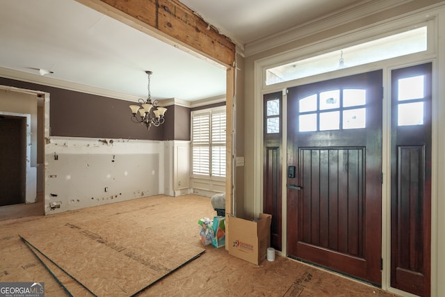 foyer entrance with a healthy amount of sunlight, crown molding, and an inviting chandelier