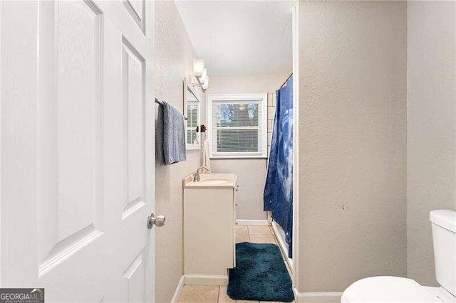 bathroom with vanity, tile patterned flooring, and toilet