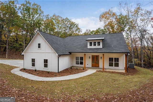 modern farmhouse with a front lawn and central air condition unit