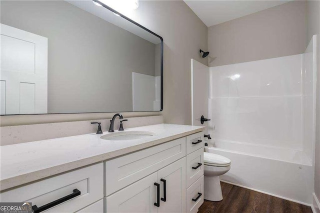 full bathroom with hardwood / wood-style floors, vanity, toilet, and bathing tub / shower combination