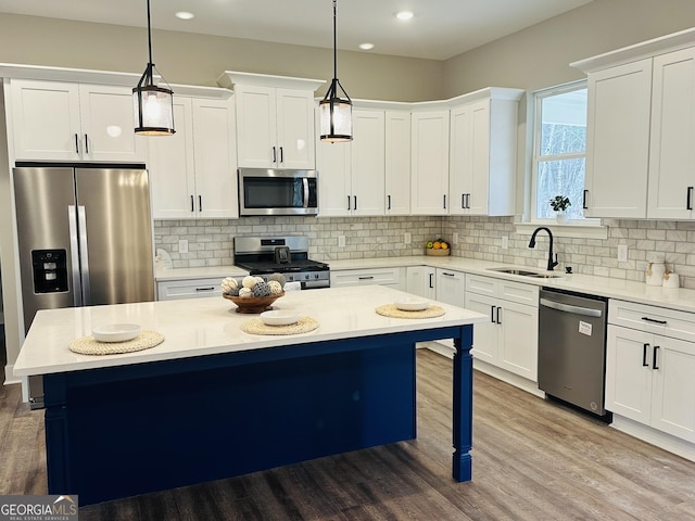 kitchen featuring stainless steel appliances, a kitchen island, hanging light fixtures, and sink