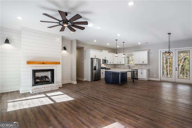 unfurnished living room featuring a fireplace, dark hardwood / wood-style flooring, ceiling fan, and sink