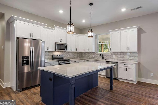 kitchen featuring pendant lighting, dark hardwood / wood-style floors, a kitchen island, white cabinetry, and stainless steel appliances