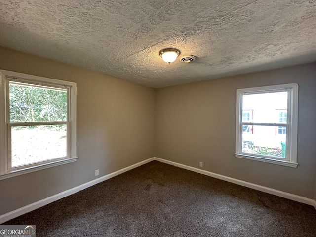 carpeted spare room featuring a textured ceiling