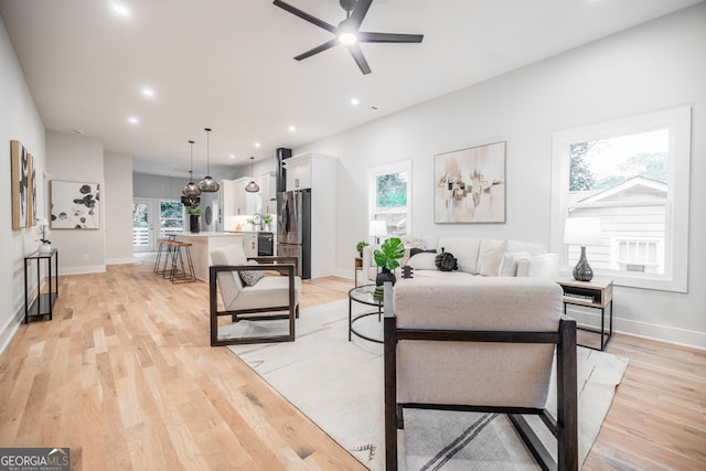 interior space featuring ceiling fan, stainless steel fridge, and light wood-type flooring