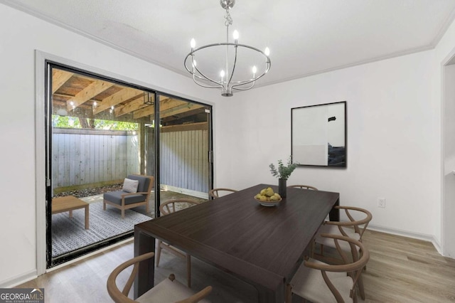 dining area featuring a chandelier, light wood-type flooring, and crown molding