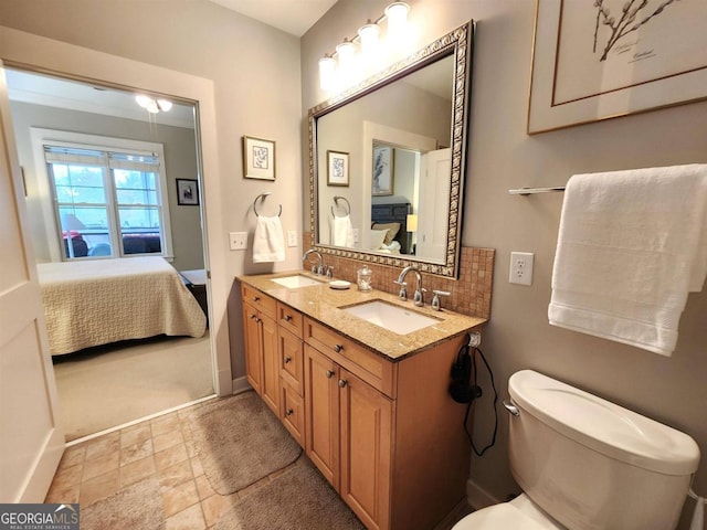 bathroom featuring vanity, toilet, and tasteful backsplash