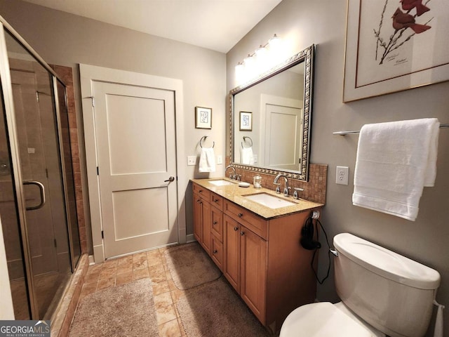 bathroom with toilet, tasteful backsplash, vanity, and a shower with shower door