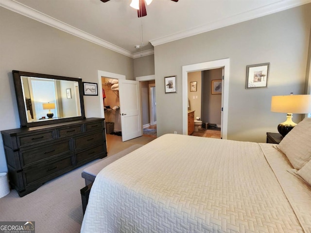 carpeted bedroom with ensuite bathroom, ceiling fan, crown molding, a closet, and a spacious closet