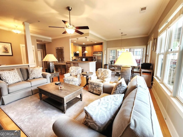 living room featuring ceiling fan, light hardwood / wood-style floors, and crown molding