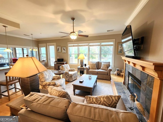 living room featuring a fireplace, ceiling fan, and ornamental molding