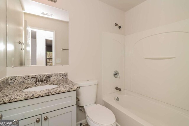 full bathroom featuring washtub / shower combination, toilet, and vanity