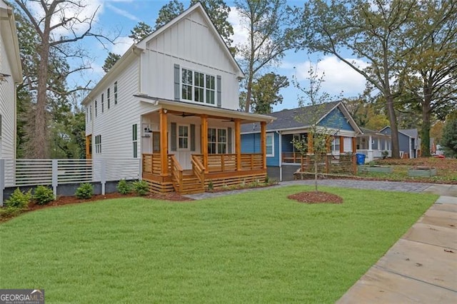 rear view of property featuring a yard and a porch