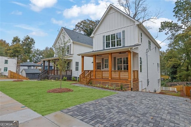 back of property featuring a lawn and covered porch