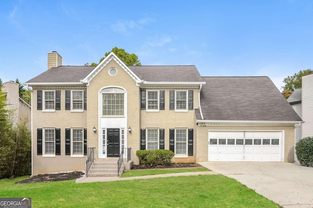 colonial house featuring a garage and a front yard