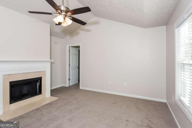 unfurnished living room featuring vaulted ceiling, light colored carpet, ceiling fan, and a textured ceiling