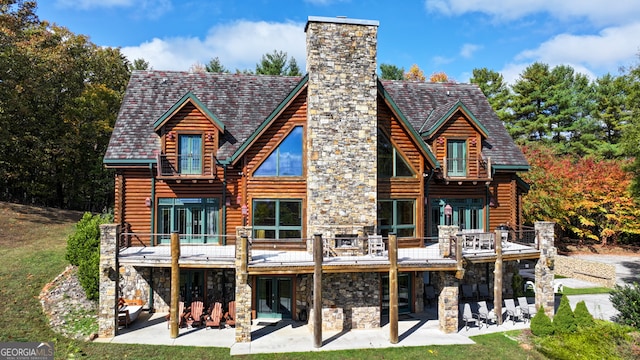 back of property with a deck and a patio