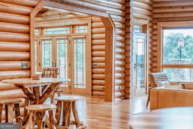 unfurnished dining area with french doors, light hardwood / wood-style flooring, and log walls