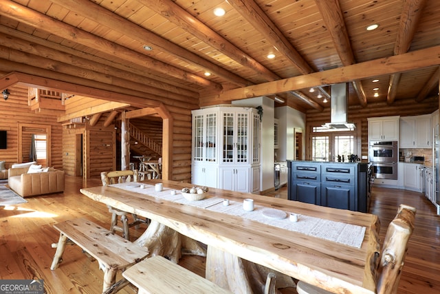 unfurnished dining area with light wood-type flooring, beam ceiling, log walls, and wood ceiling