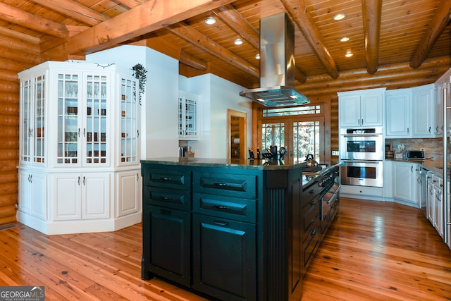 kitchen with island exhaust hood, white cabinetry, double oven, and light wood-type flooring