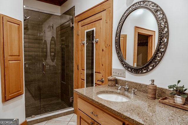 bathroom with tile patterned flooring, vanity, and a shower with door