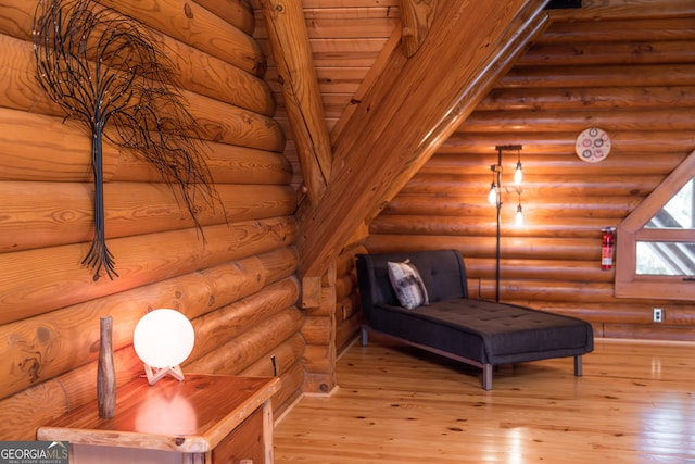 sitting room featuring rustic walls, wooden ceiling, and light hardwood / wood-style floors