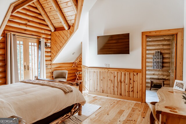 bedroom featuring wooden ceiling, beamed ceiling, rustic walls, high vaulted ceiling, and light hardwood / wood-style flooring