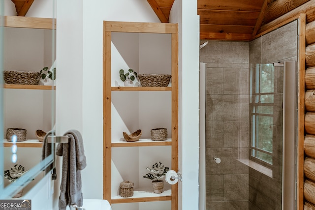 bathroom featuring lofted ceiling, a tile shower, and wooden ceiling