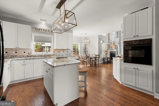 5 Arabian Ave, Alpharetta, GA 30004 - kitchen with a notable chandelier, decorative backsplash, a kitchen island, white cabinets, and oven