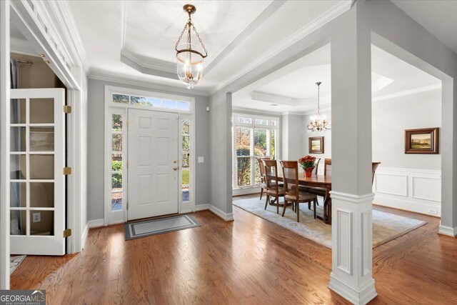 5 Arabian Ave, Alpharetta, GA 30004 - dining area featuring wood finished floors, a notable chandelier, crown molding, wainscoting, and stairs