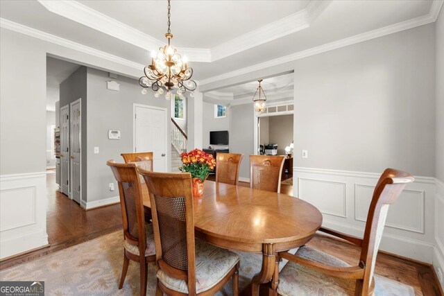 5 Arabian Ave, Alpharetta, GA 30004 - dining area featuring wood finished floors, a notable chandelier, crown molding, wainscoting, and stairs