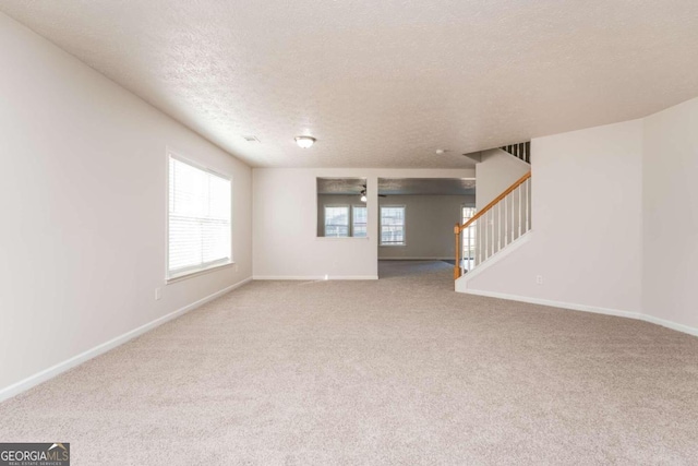 unfurnished living room featuring a textured ceiling and carpet flooring