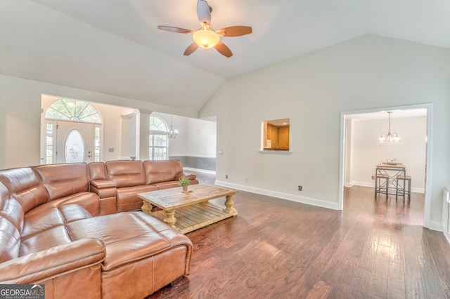 living room with ceiling fan with notable chandelier, lofted ceiling, dark wood-type flooring, and decorative columns