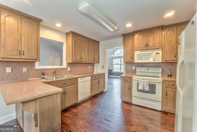 kitchen with sink, kitchen peninsula, white appliances, dark wood-type flooring, and decorative backsplash