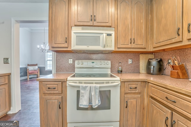 kitchen with dark wood-type flooring, white appliances, a notable chandelier, and backsplash