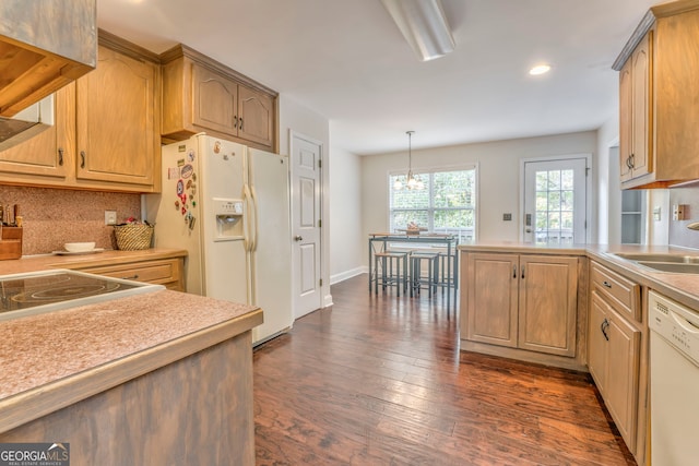 kitchen featuring tasteful backsplash, decorative light fixtures, white appliances, a chandelier, and dark wood-type flooring