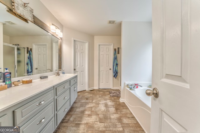 bathroom featuring shower with separate bathtub and vanity