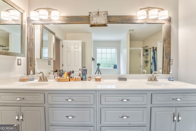 bathroom with a shower with shower door and vanity