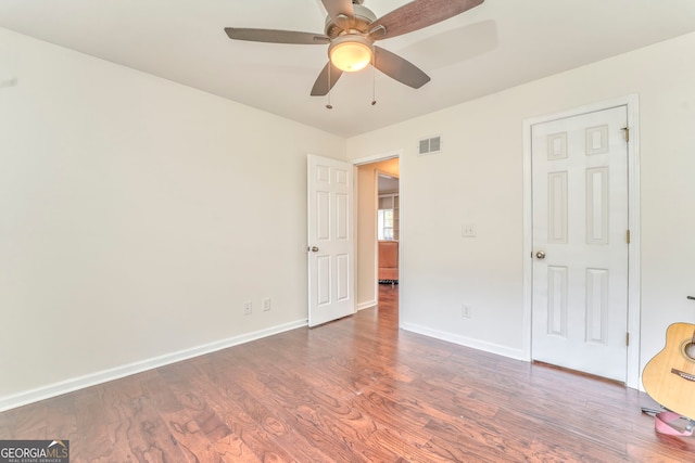 unfurnished bedroom with ceiling fan and dark hardwood / wood-style floors